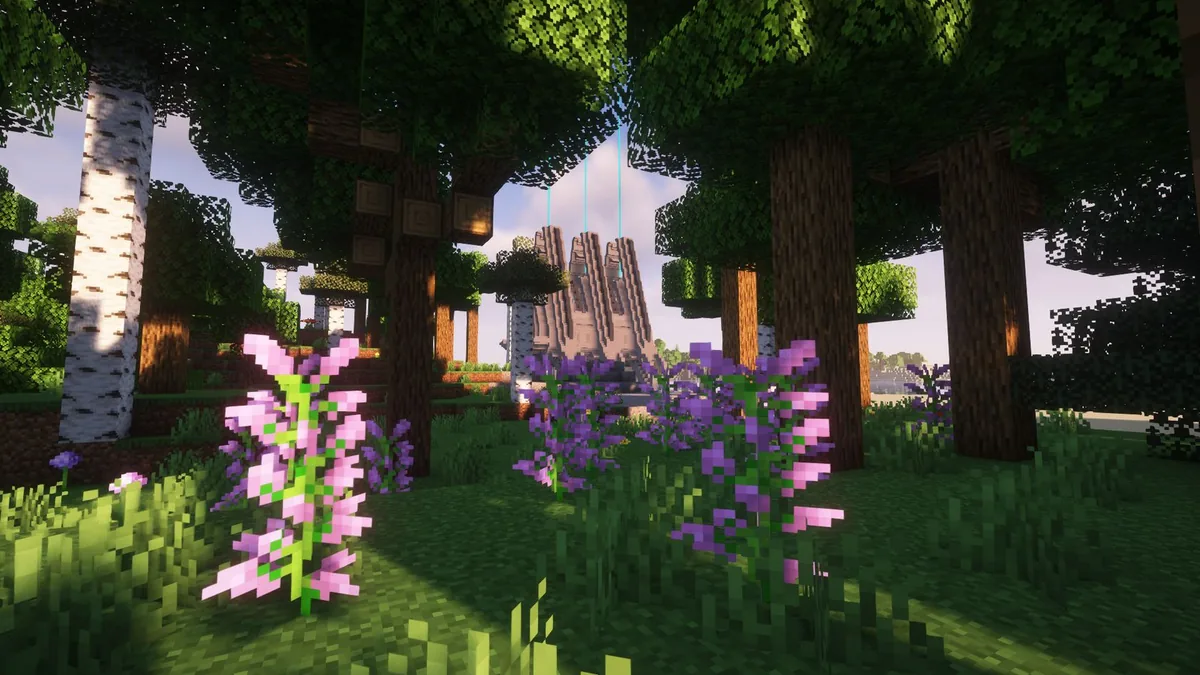 Sendero arbolado con flores y una estructura a lo lejos
